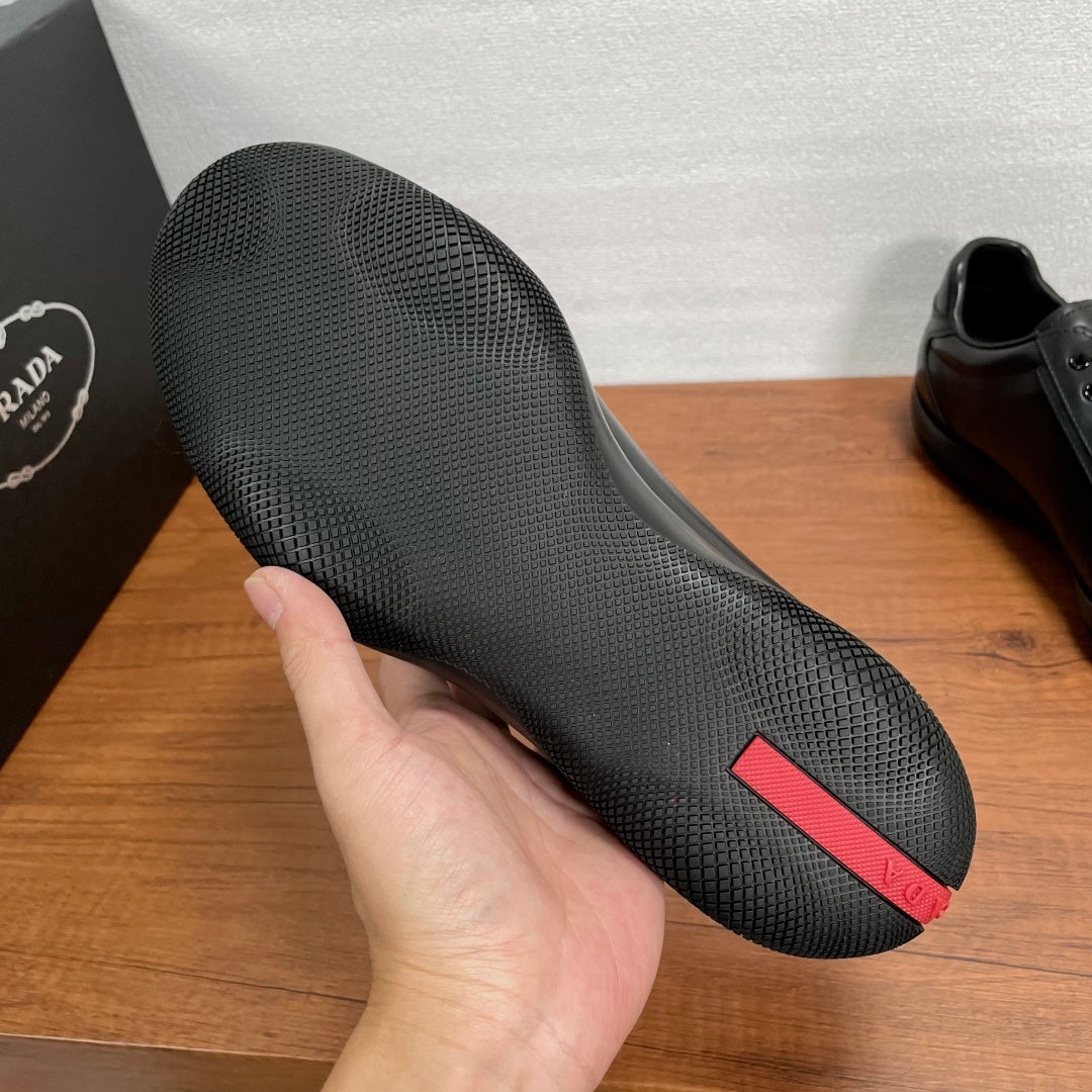Dark sneaker outsole with textured tread and red logo stripe detail