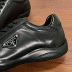 Close-up of dark leather sneaker with lace-up panel and triangular logo