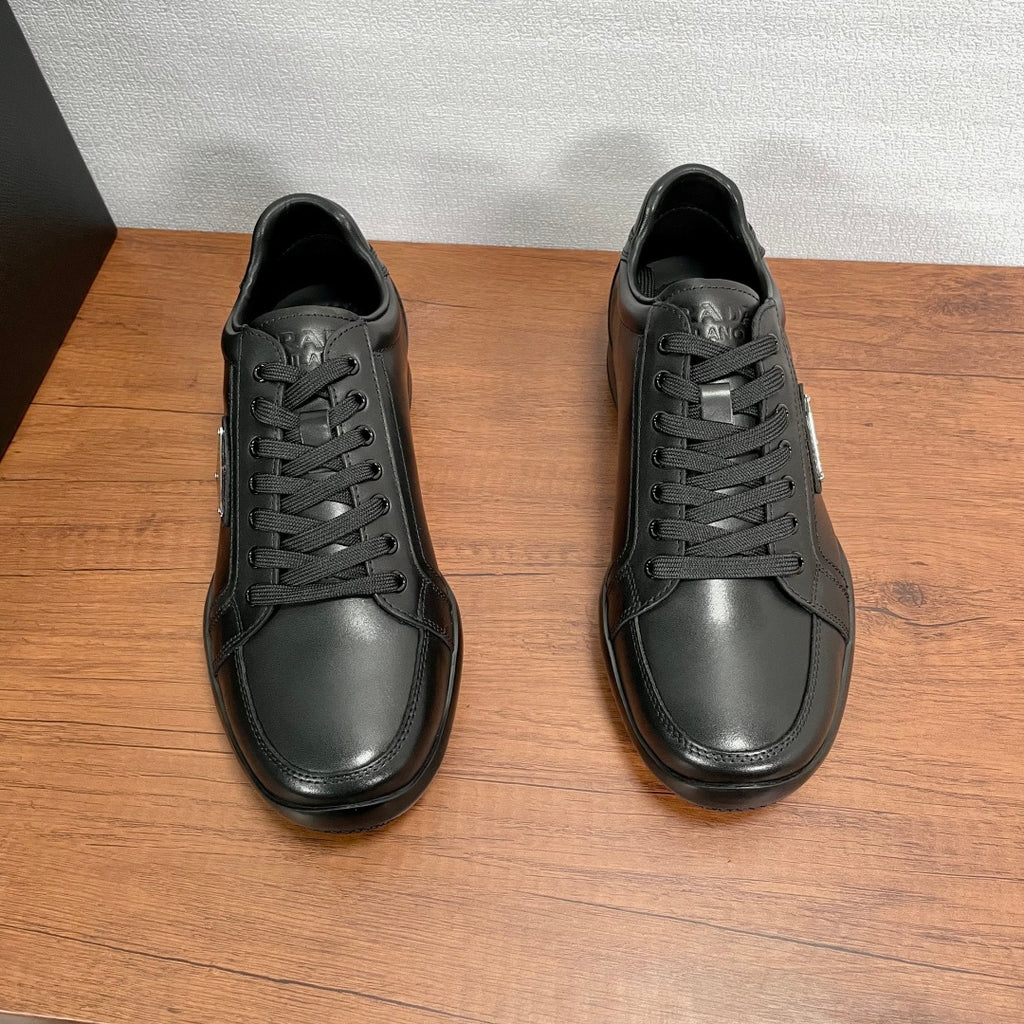 Pair of dark leather unisex sneakers shown from top, with lace-up front
