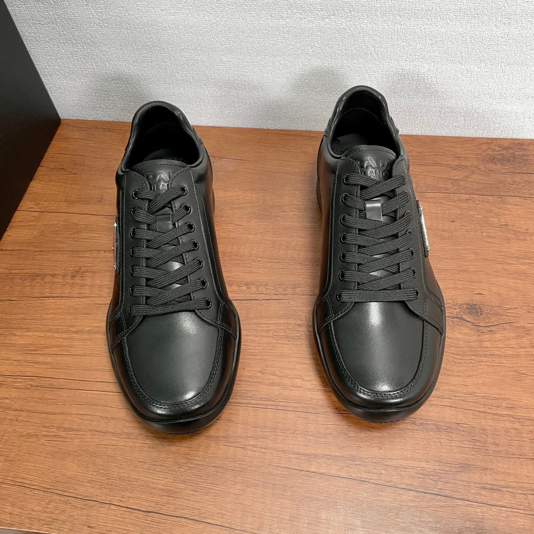 Pair of dark leather unisex sneakers shown from top, with lace-up front