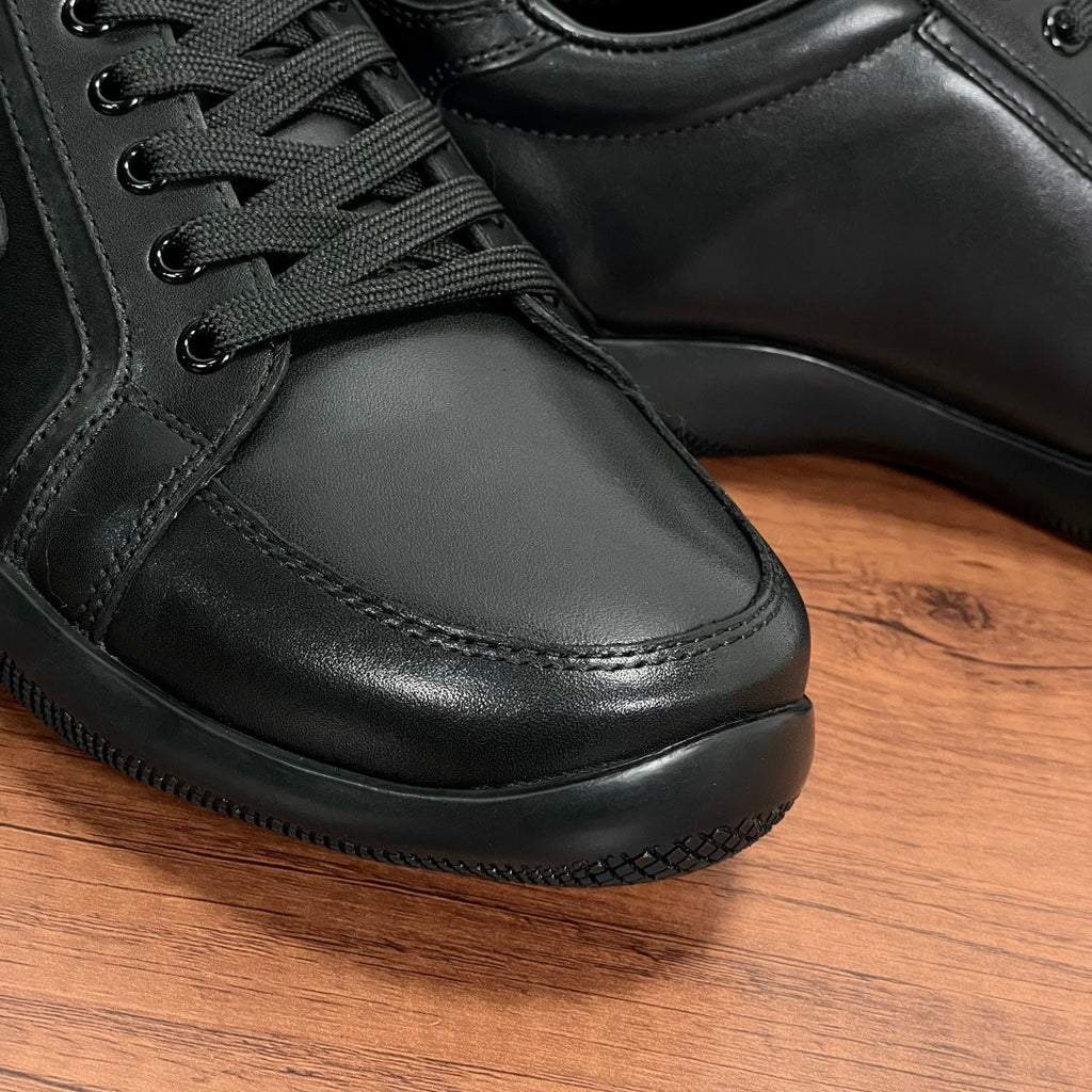 Close-up of dark leather sneaker toe and laces with stitched side panels