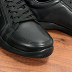 Close-up of dark leather sneaker toe and laces with stitched side panels