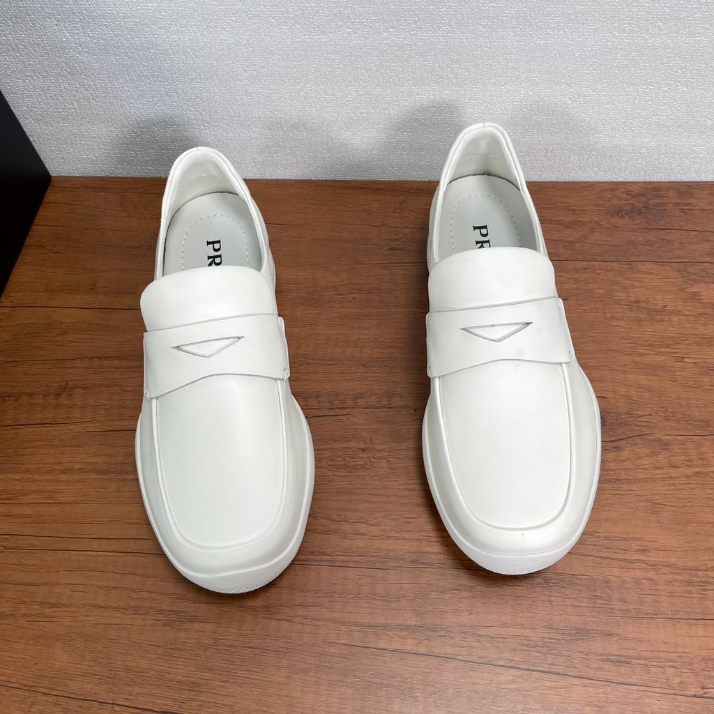 White Prada unisex slip-on loafers, front view with stitched strap detail
