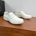 Pair of white Prada unisex slip-on loafers with strap and low rubber sole