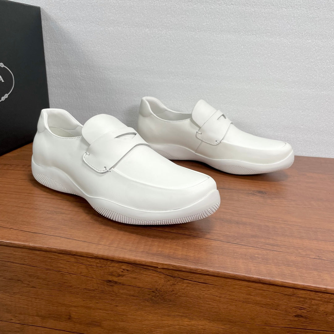 Pair of white Prada unisex slip-on loafers with strap and low rubber sole