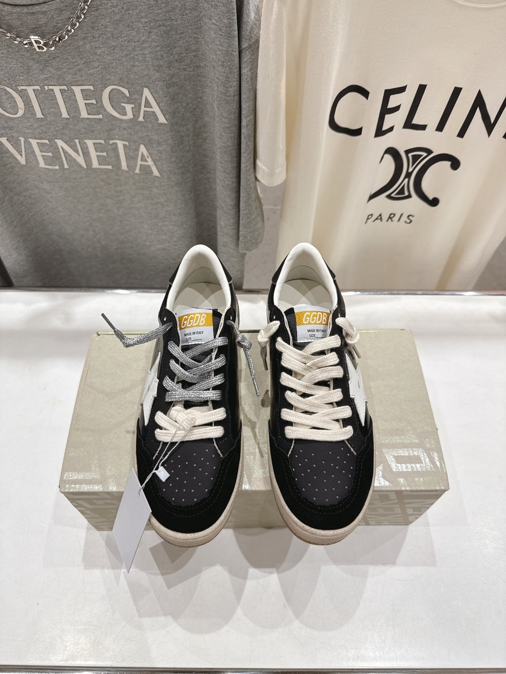 Black low-top sneakers with white laces and white star side detail