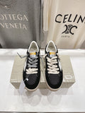 Black low-top sneakers with white laces and white star side detail