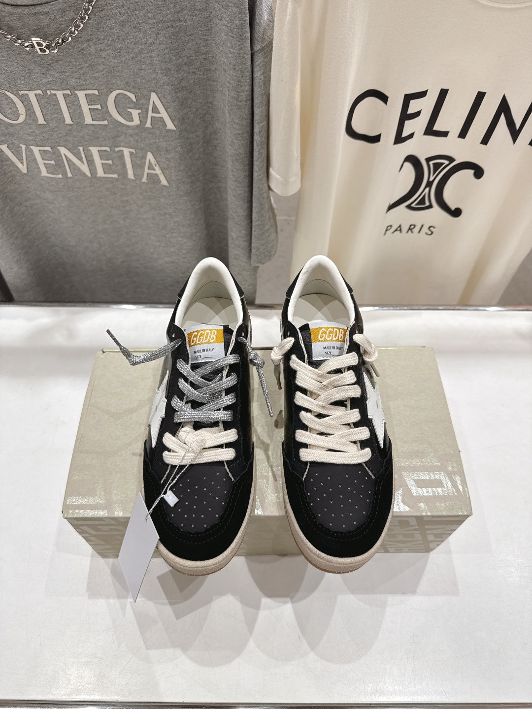Black low-top sneakers with white laces and white star side detail
