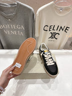 Black low-top sneakers showing outsole with tan rubber tread