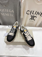 Pair of black low-top sneakers with white laces on display