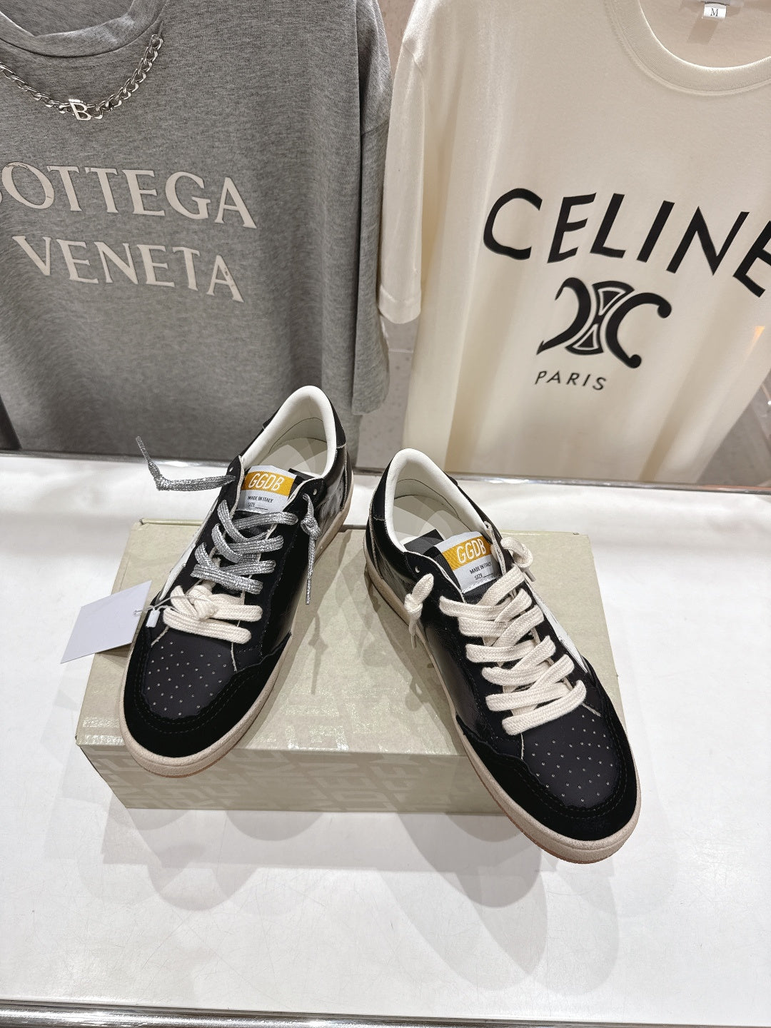 Pair of black low-top sneakers with white laces on display