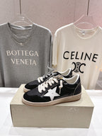 Black low-top sneakers with white star applique and white laces