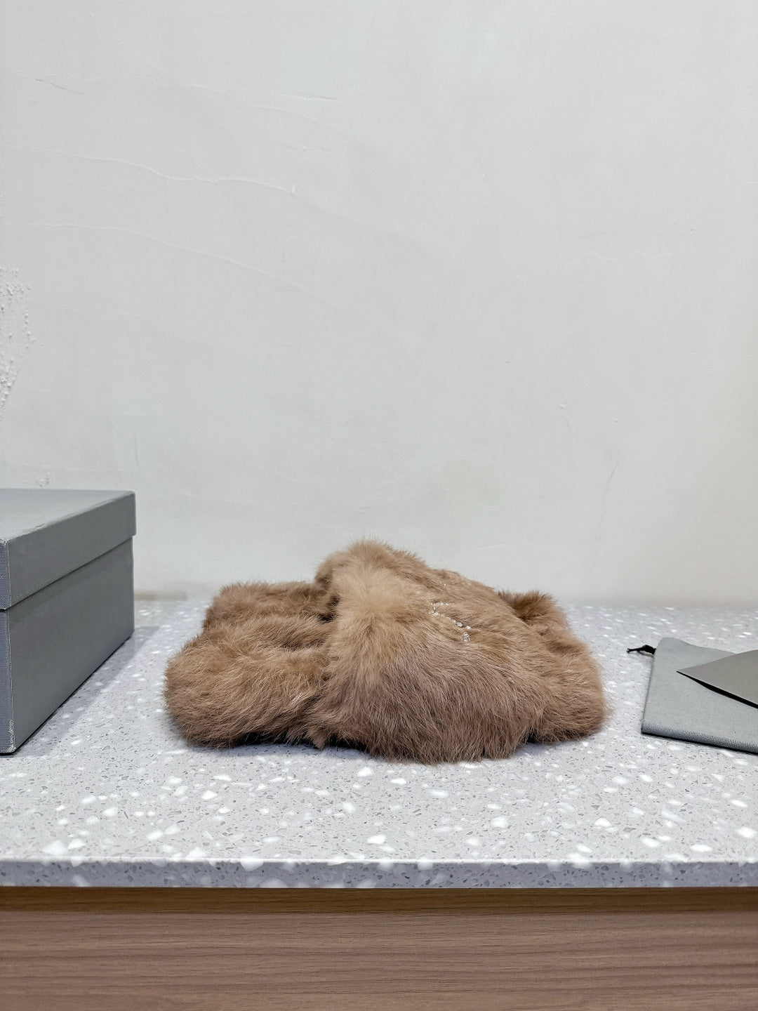Taupe faux-fur slide sandals with rhinestone bow detail on the upper