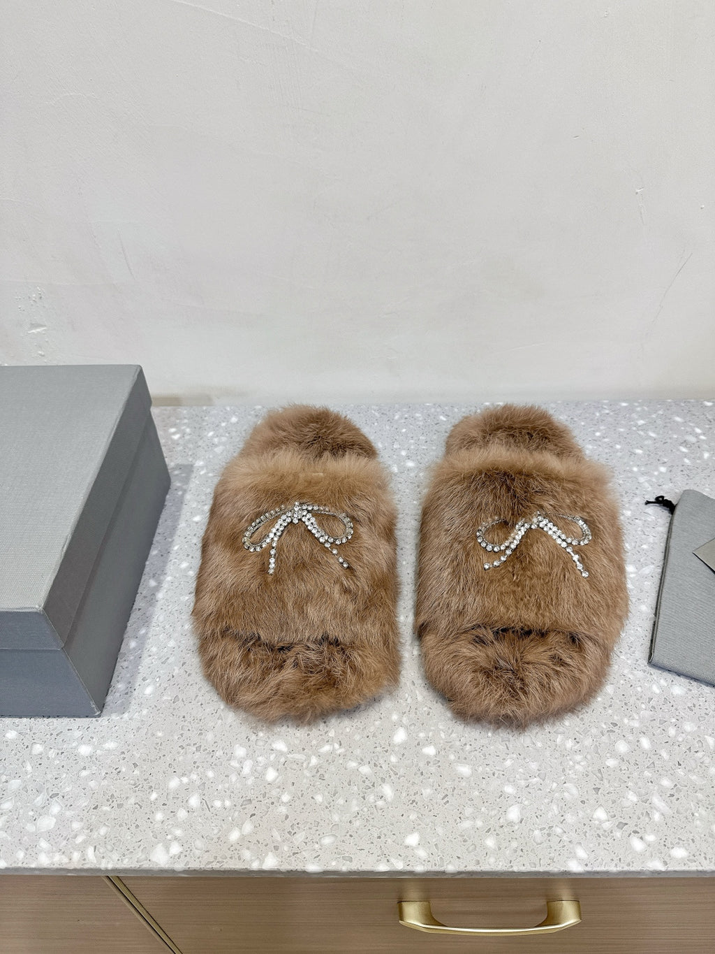 Taupe faux-fur sandals with rhinestone bow detail on the top