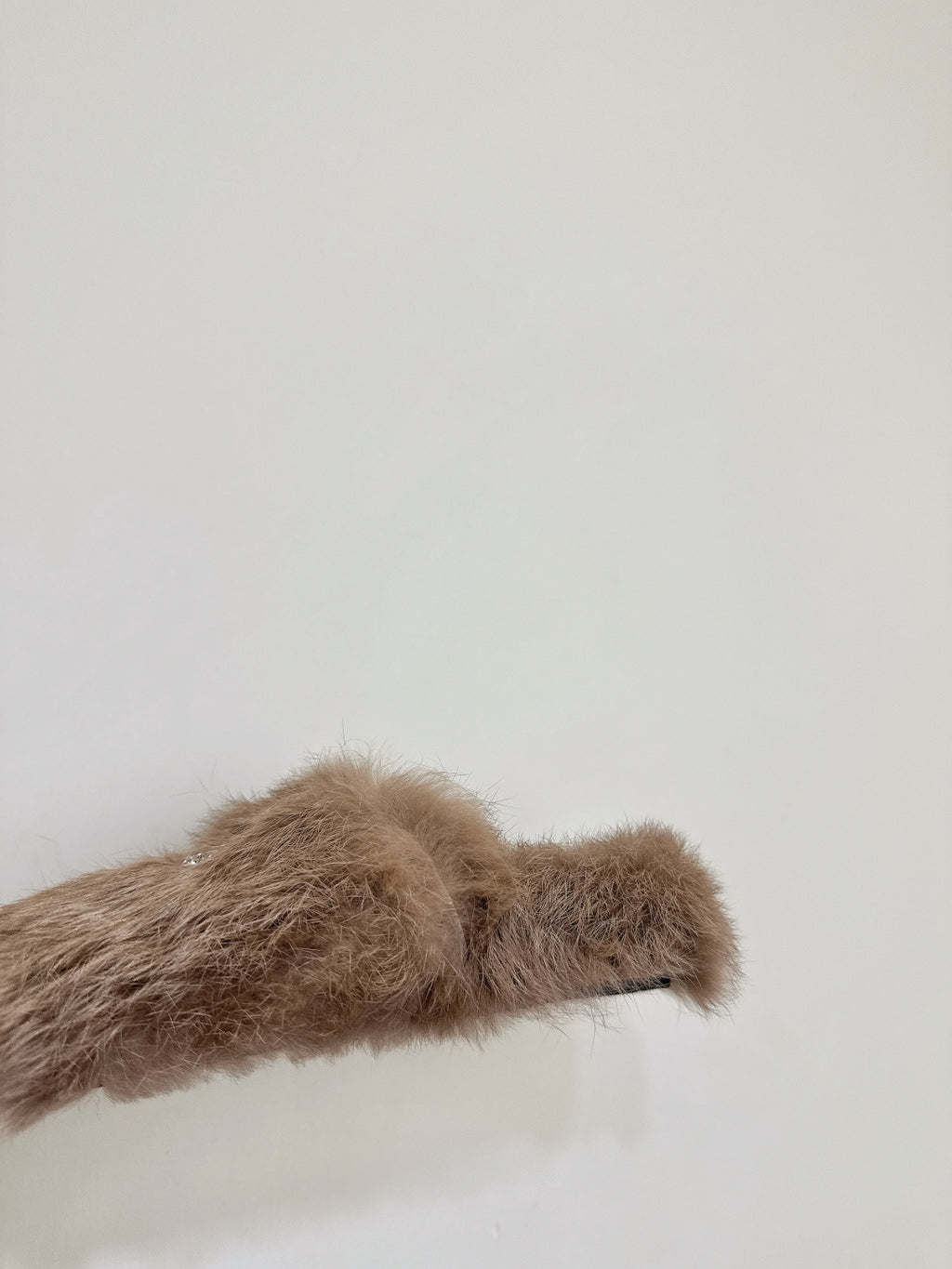 Taupe faux-fur slide sandal upper close-up with curved strap