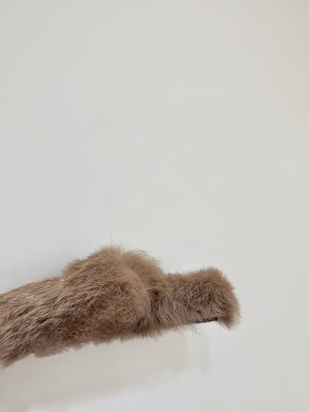 Taupe faux-fur slide sandal upper close-up with curved strap