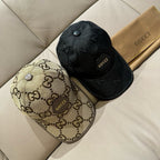 Gucci cap set: beige and black GG monogram caps with curved brims.