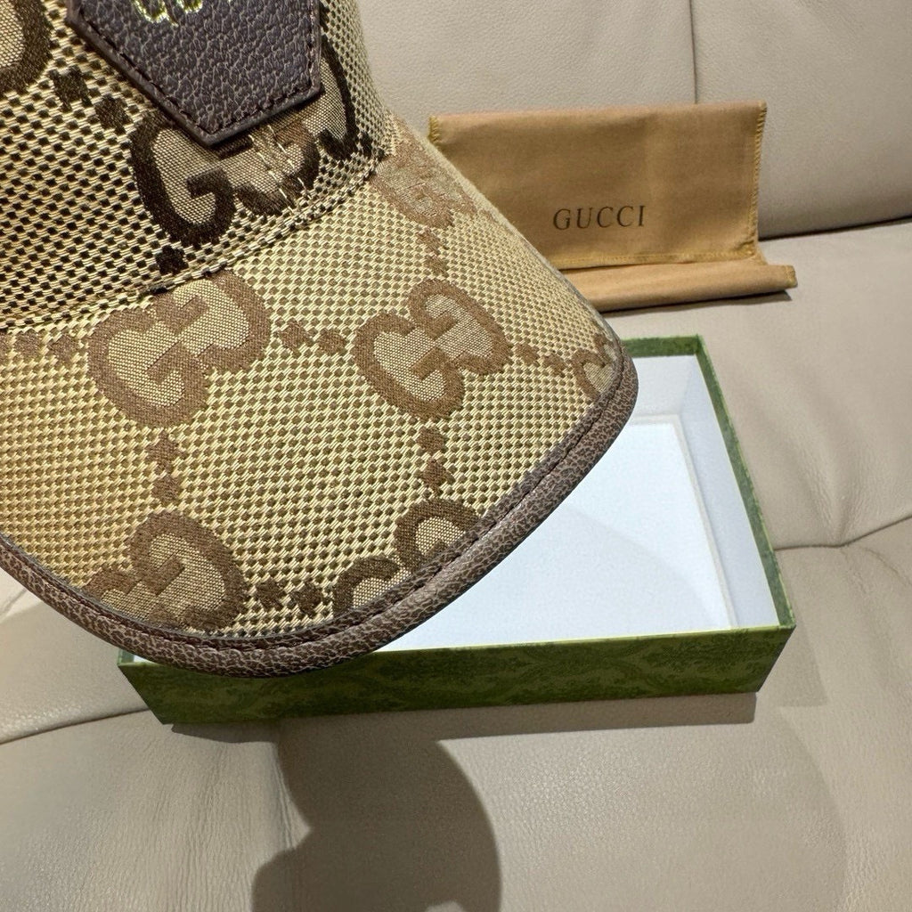 Gucci cap close-up of beige GG monogram brim and side panel stitching.