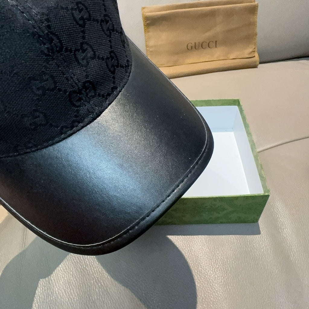 Black Gucci cap close-up: GG pattern crown and smooth leather-look brim
