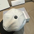 Light baseball cap with black button top and stitched crown seam detail