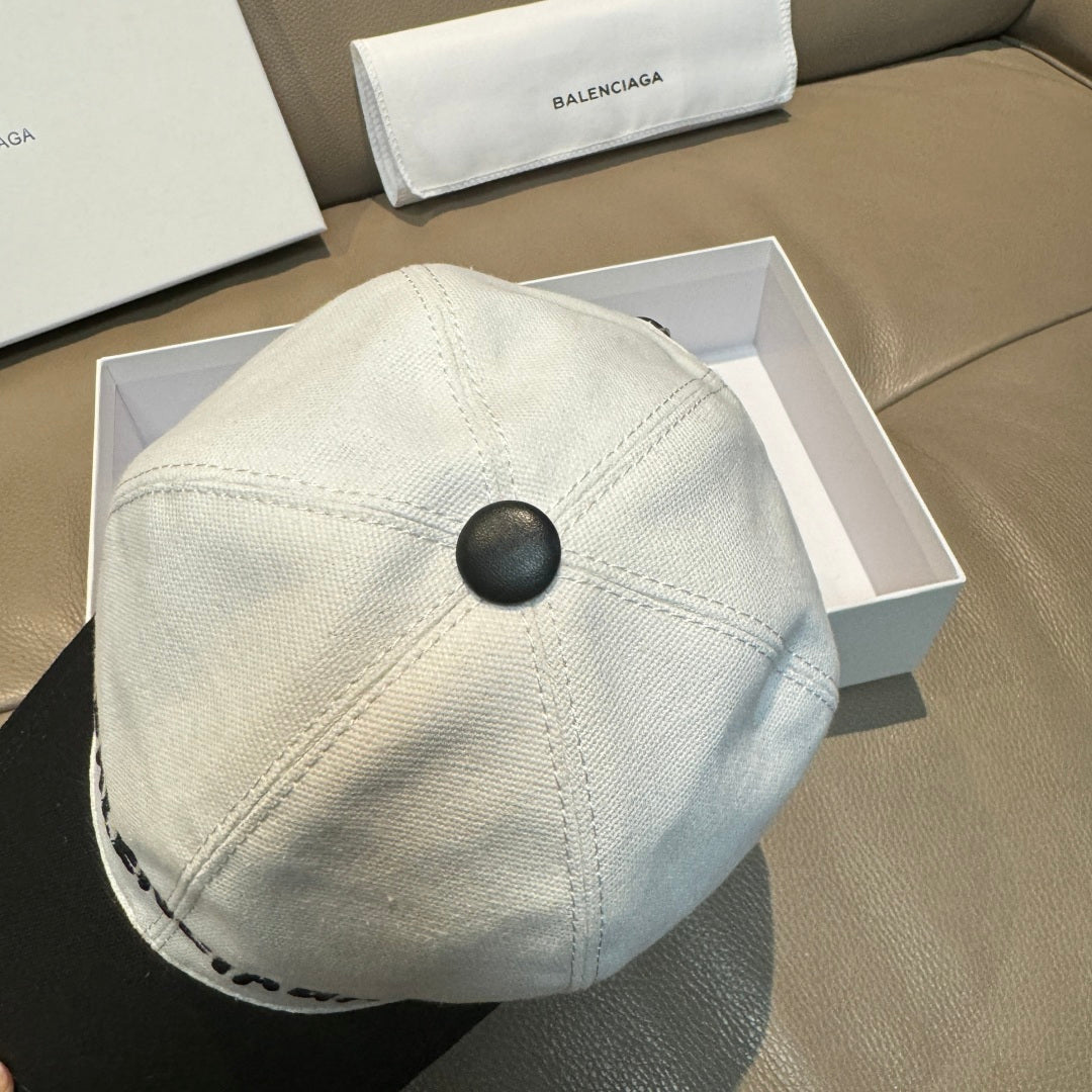 Light baseball cap with black button top and stitched crown seam detail