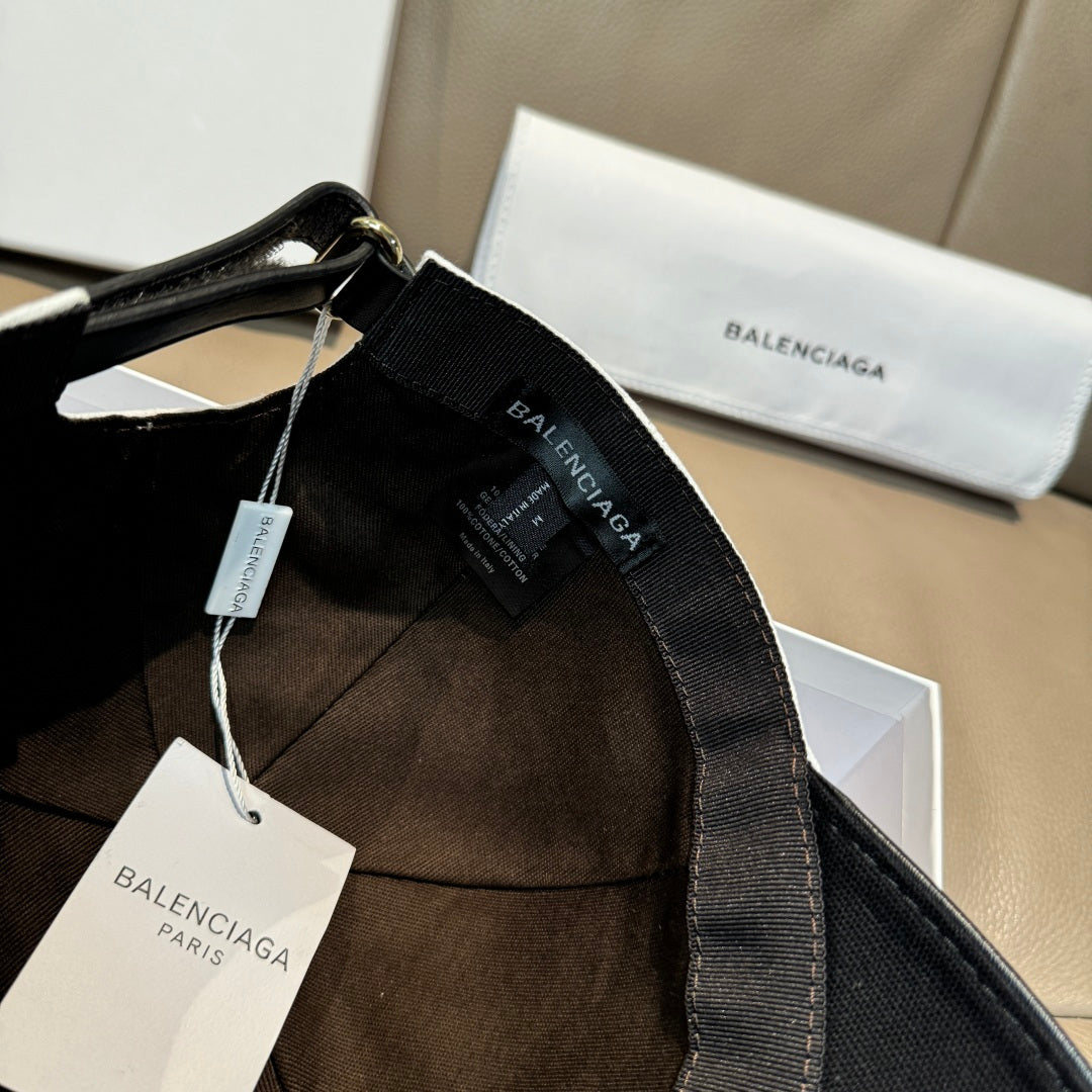Black cap with inner label, tags, and adjustable strap; BALENCIAGA embroidery.