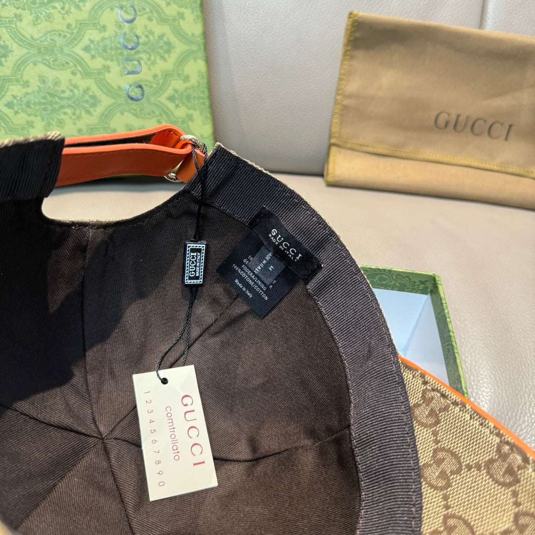 Gucci cap with black fabric, adjustable strap, and orange trim with logo tag