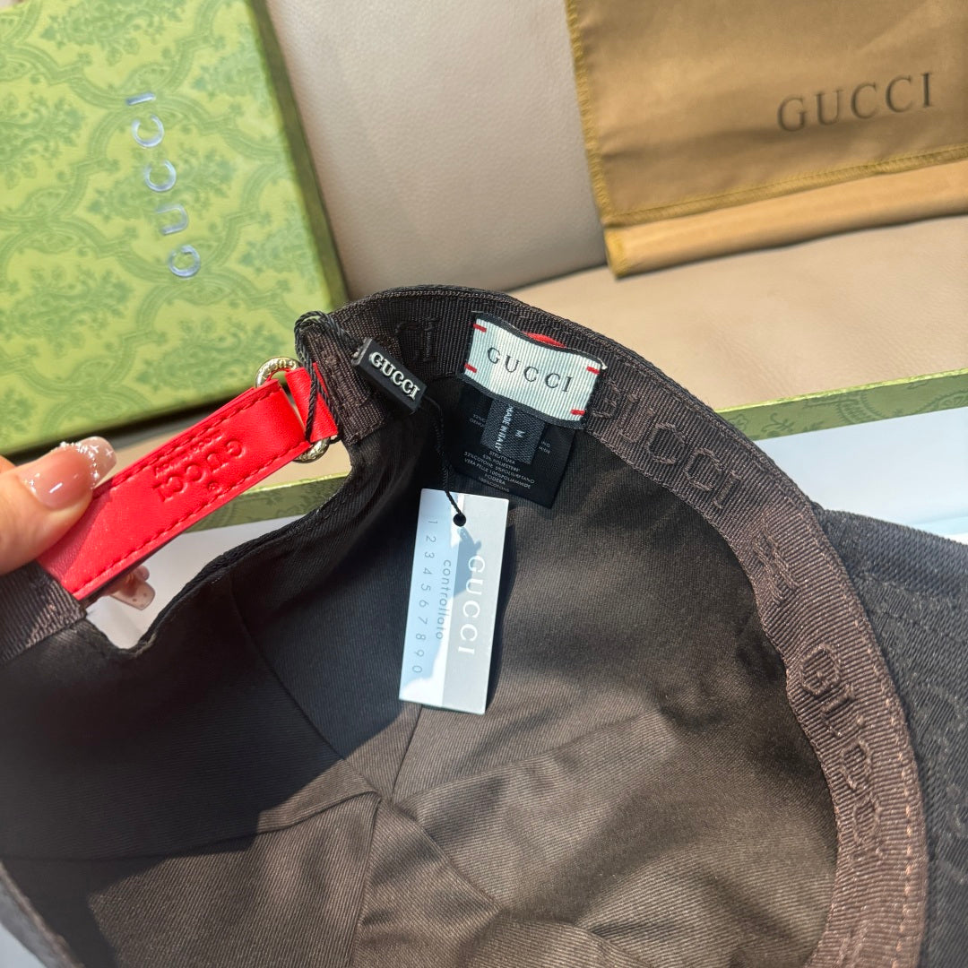 Black Gucci cap interior with adjustable web strap, red detail, and hanging tag