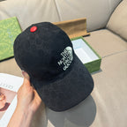 Black GG baseball cap angled view with The North Face Gucci logo and red button