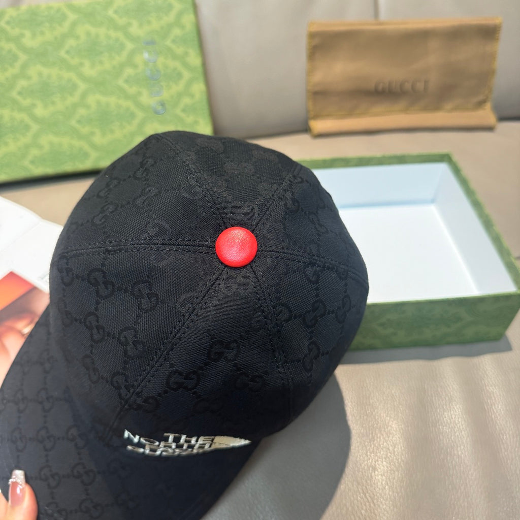 Black GG baseball cap top view with red button and The North Face Gucci patch