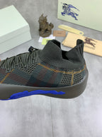 Burberry knit sneakers close-up of stretchy collar and blue sole edge on dark upper