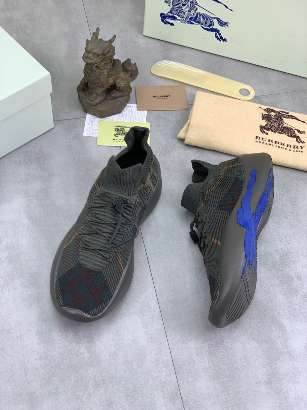 Burberry knit sneakers with dark plaid upper and blue side accent, side and heel views
