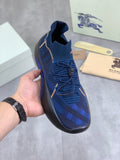 Burberry blue knit sneaker with black rubber sole, gold trim and blue plaid pattern