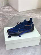 Burberry blue knit sneaker on white box, black outsole and gold trim laces