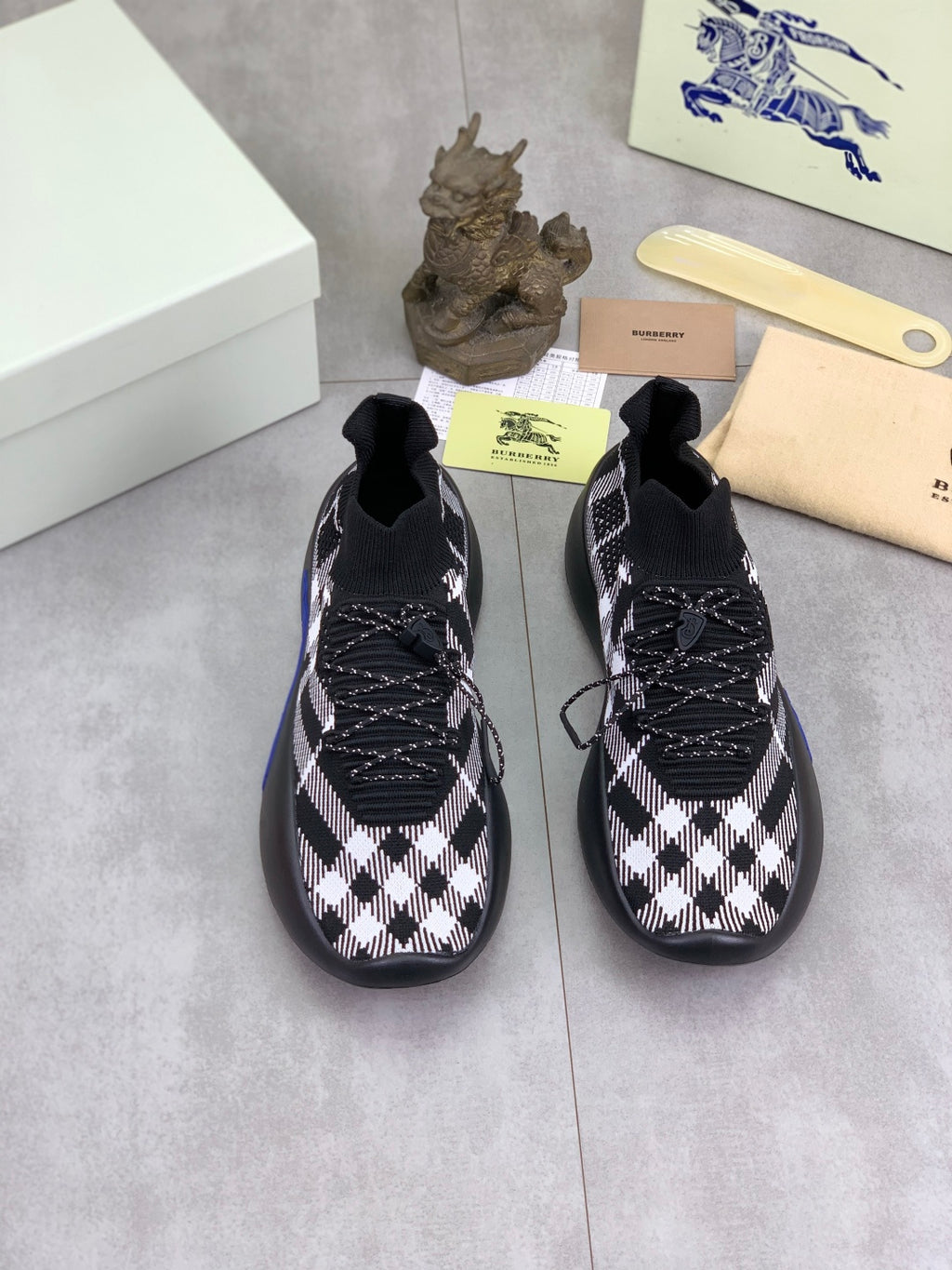 Pair of black and white check knit sneakers with lace-up details and blue soles