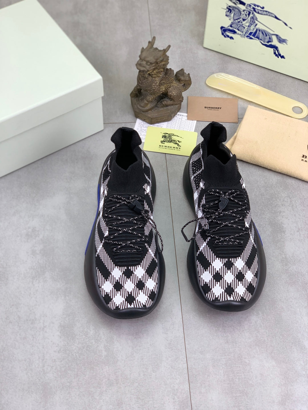 Pair of black and white check knit sneakers with lace-up details and blue soles