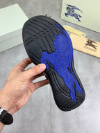 Black outsole of sneaker with raised blue bull logo grip texture