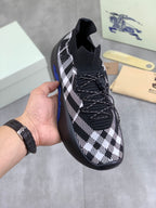 Burberry black and white check knit slip-on sneaker with blue sole and elastic collar