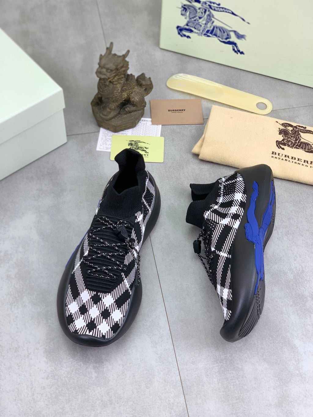Black and white check knit sneakers, side view with textured laces and blue accents
