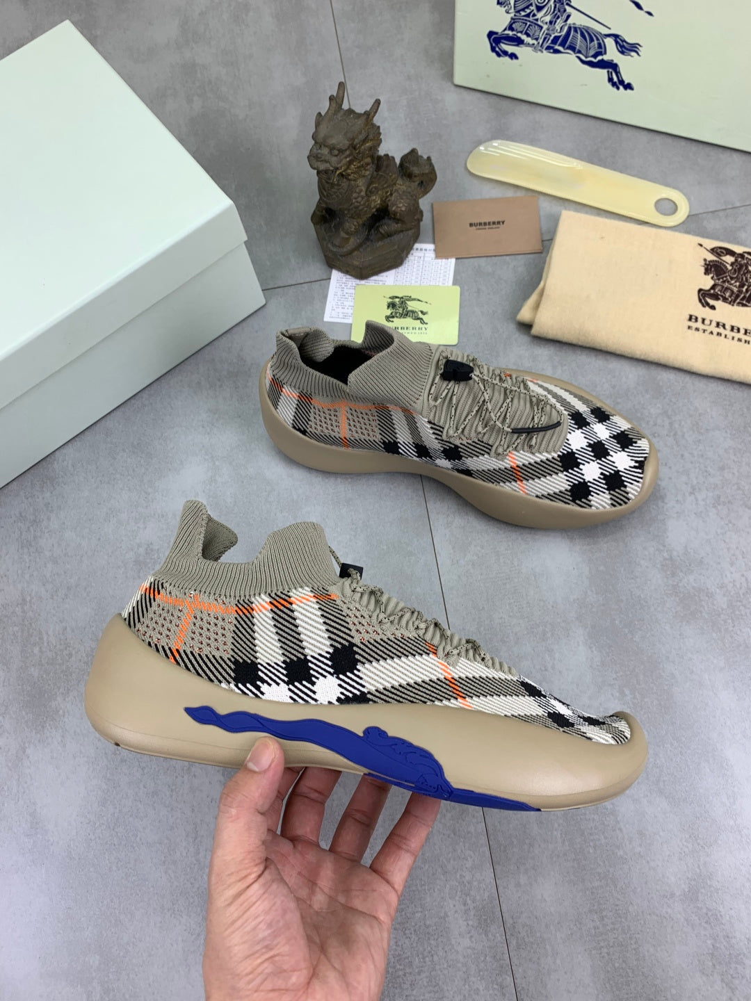 Knit pull-on sneaker with black-and-white check pattern and blue sole stripe
