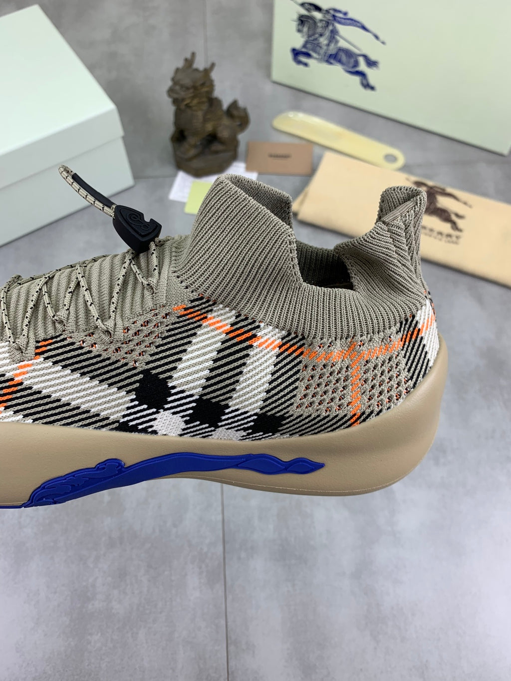 Knit pull-on sneaker with black-and-white check pattern and blue midsole