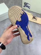 Outsole view of knit pull-on sneaker with blue rubber tread on beige base