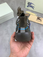 Burberry sneaker heel view, dark olive/gray knit with black-and-white check and blue accents