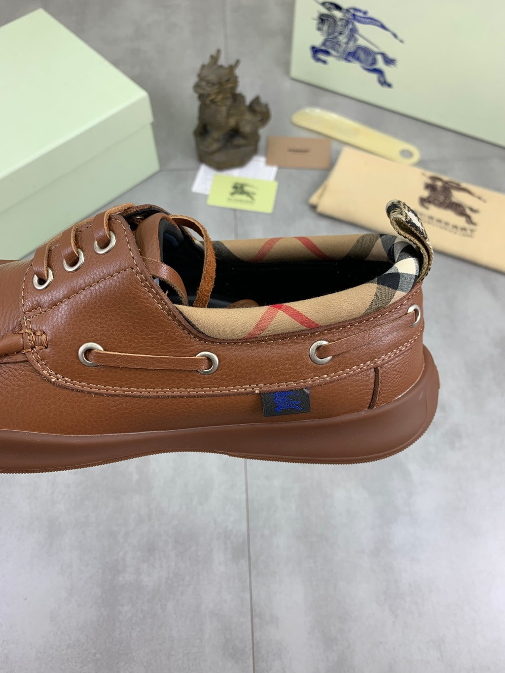 Burberry brown boat shoe with open collar showing check-lined interior