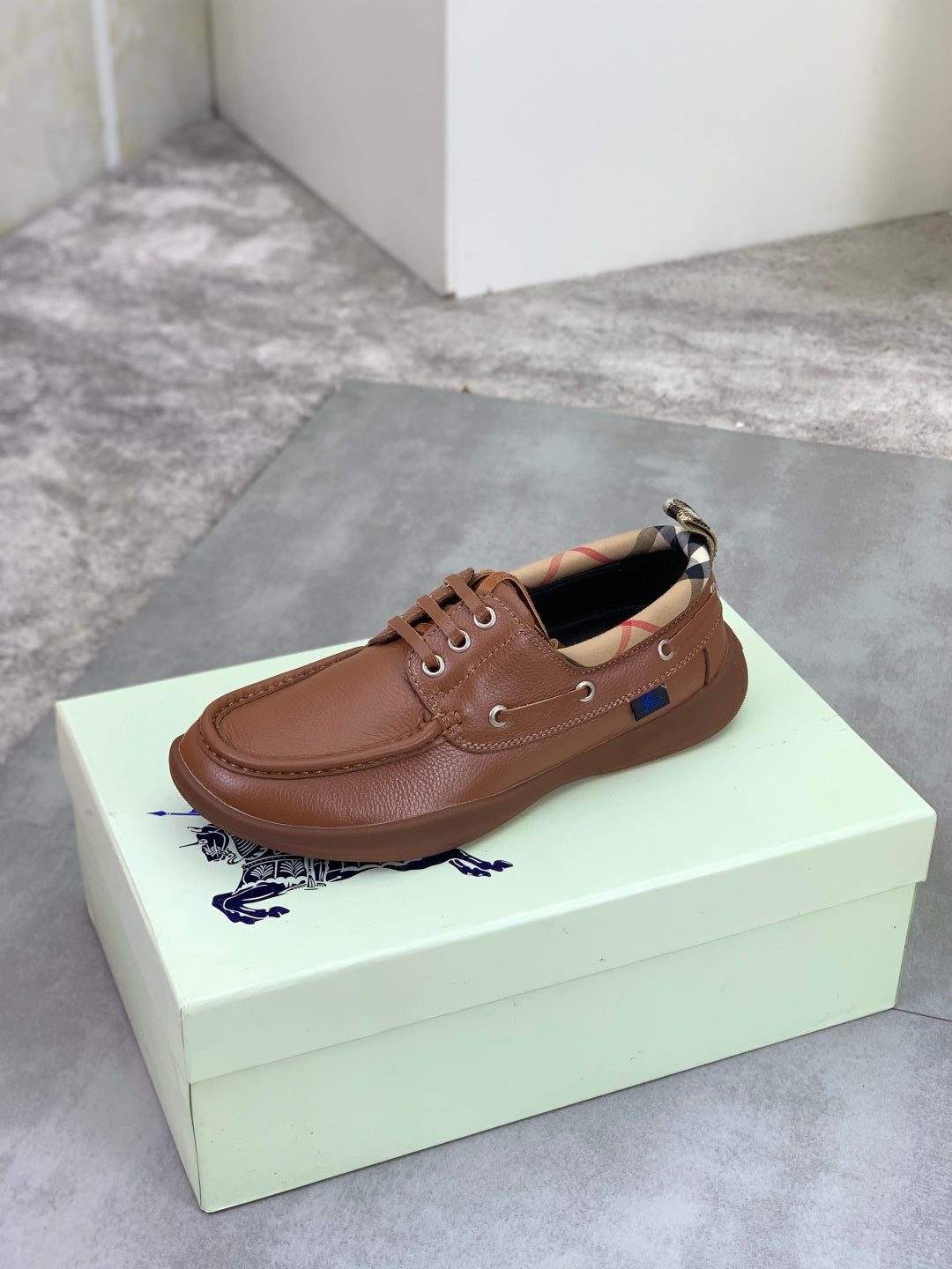 Burberry brown leather boat shoe with lace-up eyelets and cushioned lining opening