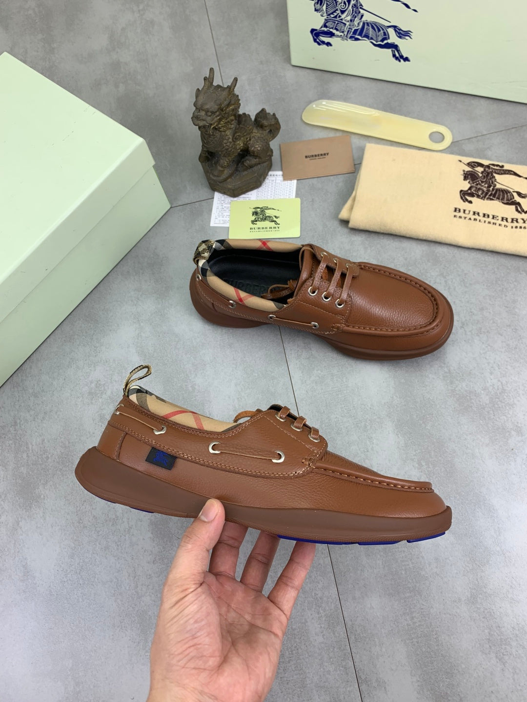 Burberry brown leather boat shoes set with lace-up vamps and textured rubber soles