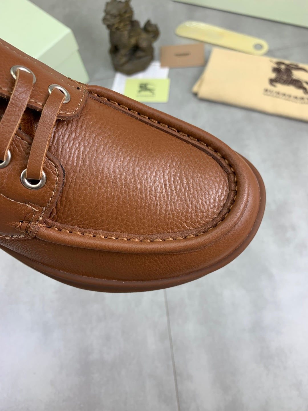 Burberry brown leather boat shoe detail with stitched moc toe and metal lace eyelets