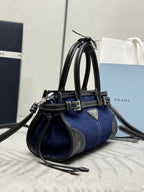 Prada handbag with navy denim body, black leather trim, and top handles with buckles