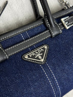 Prada logo triangle patch on dark blue mini bag with black leather trim and stitching