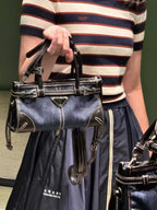 Denim Prada bag with structured top handles, front triangle logo, and shoulder strap